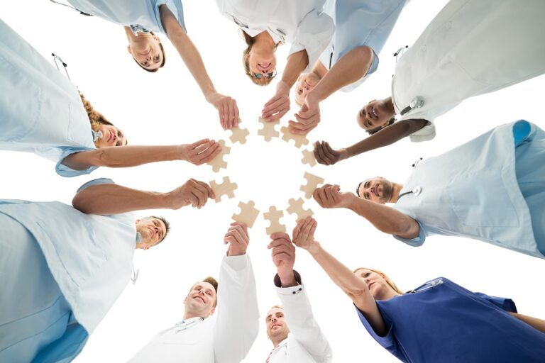 Medical team joining jigsaw pieces in huddle